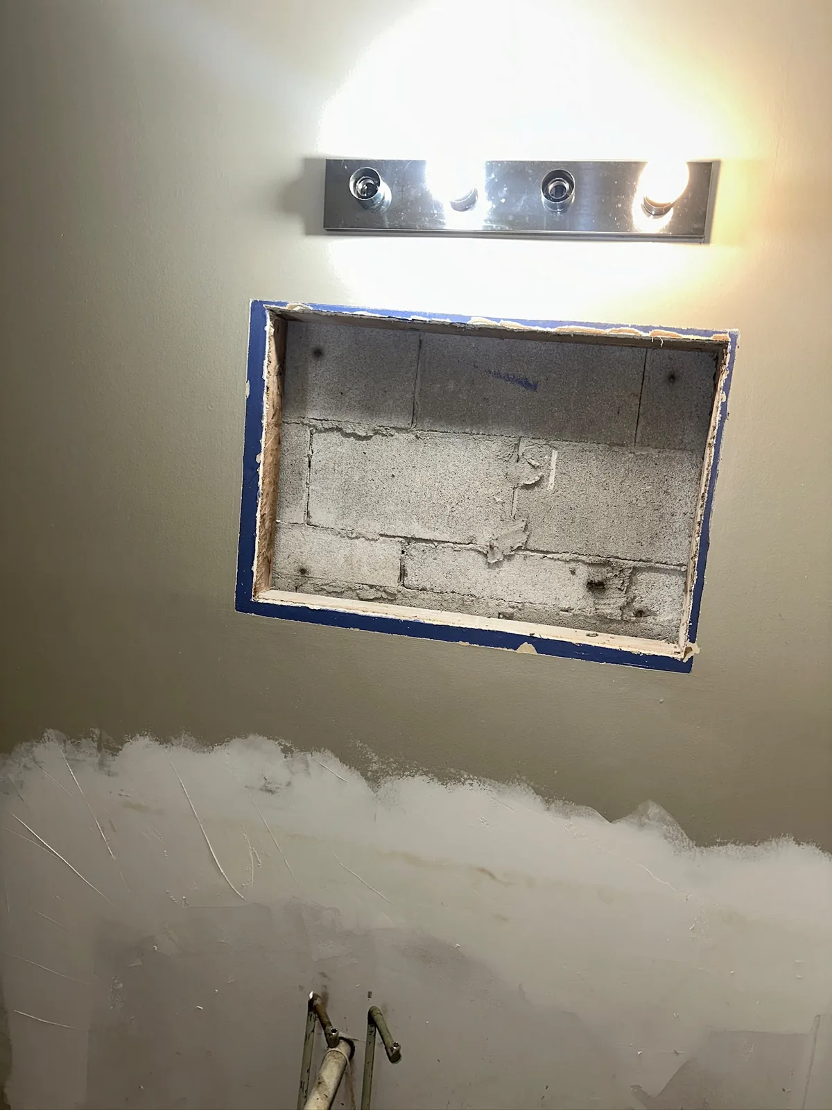 Drywall work in progress in Kitchener with a rectangular wall opening and joint compound below