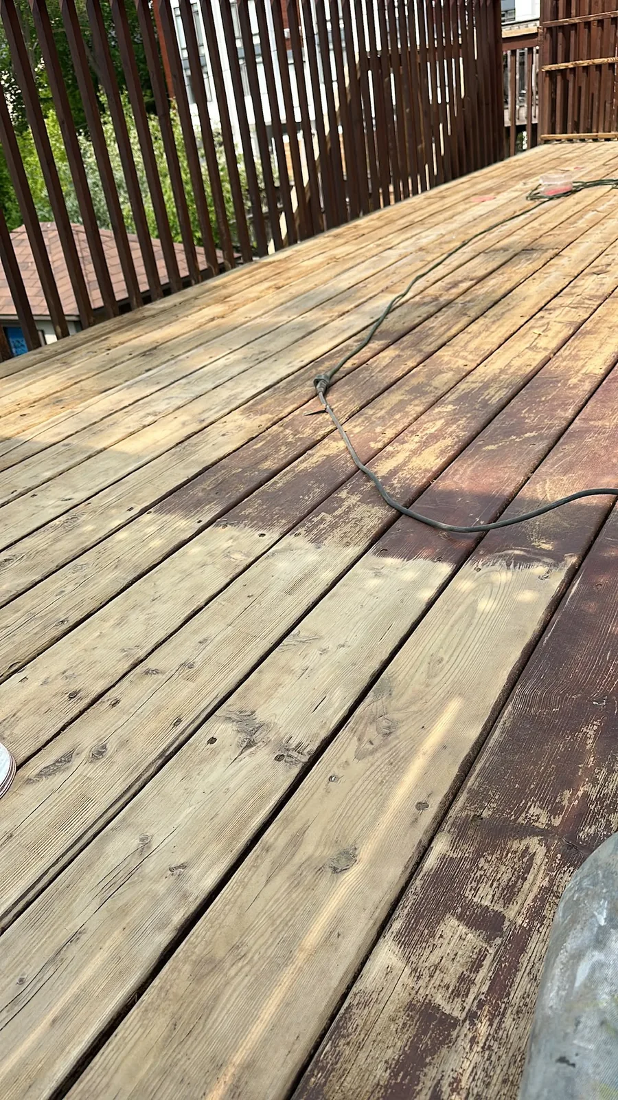 Wood deck before repair and painting, with the worn surface being stripped