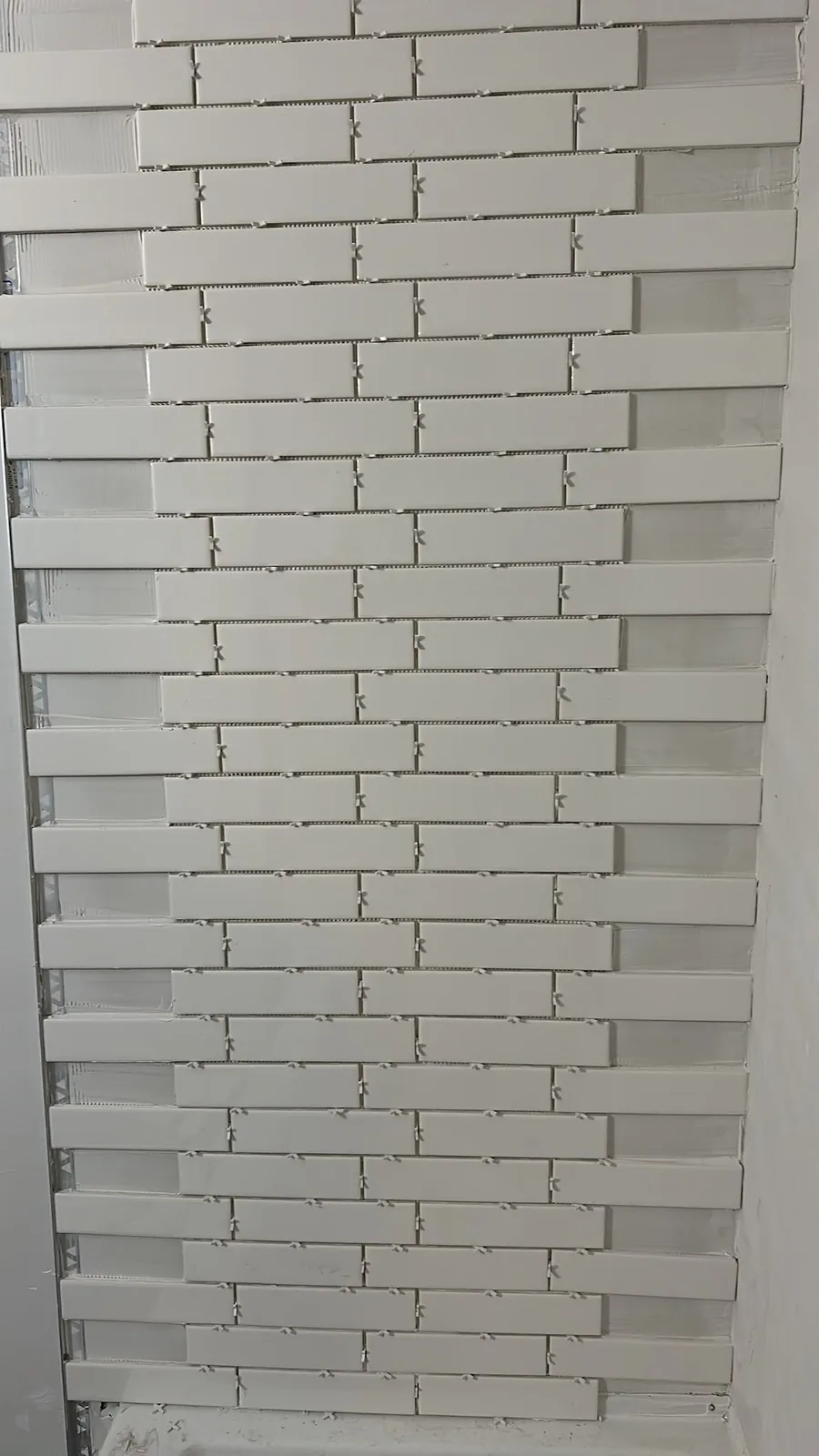 Bathroom renovation in Kitchener with white wall tiles being installed around the tub