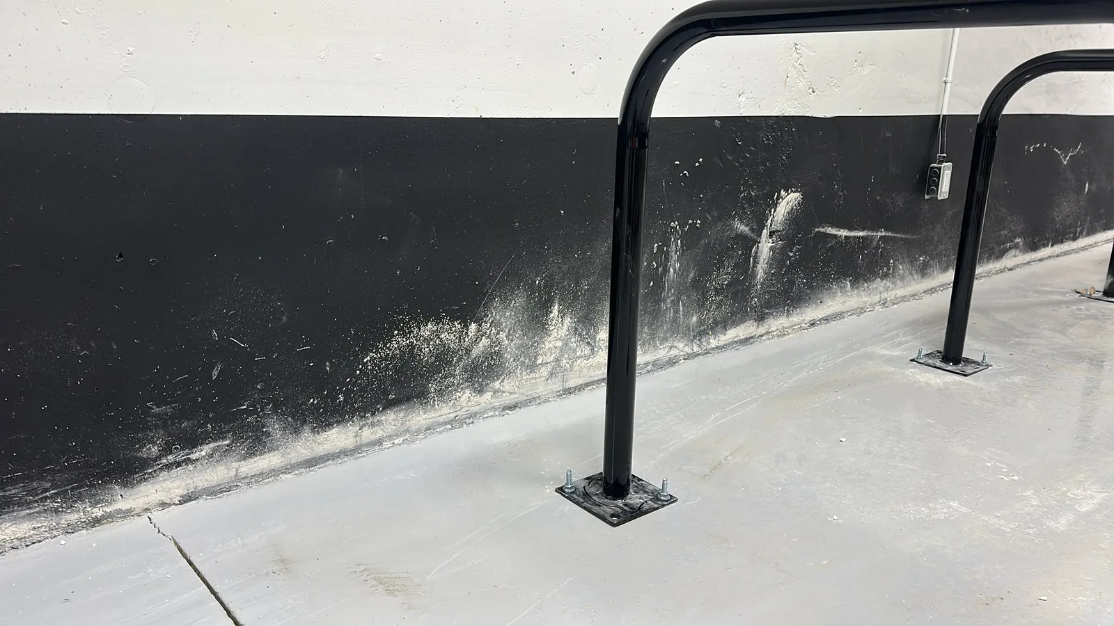 Commercial wall in Cambridge before painting, showing worn black and white surfaces