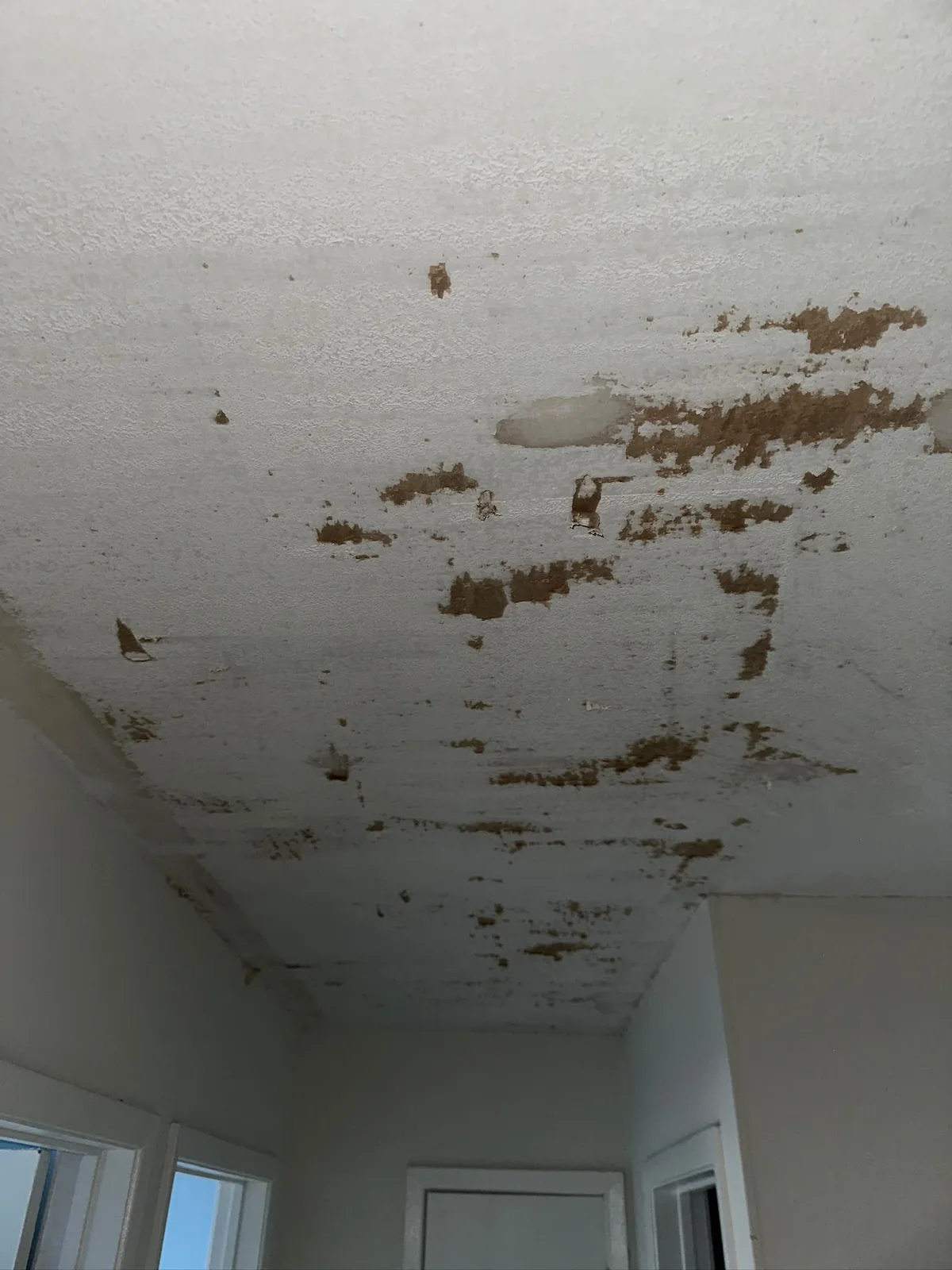 Residential ceiling before renewal with peeling and damaged paint