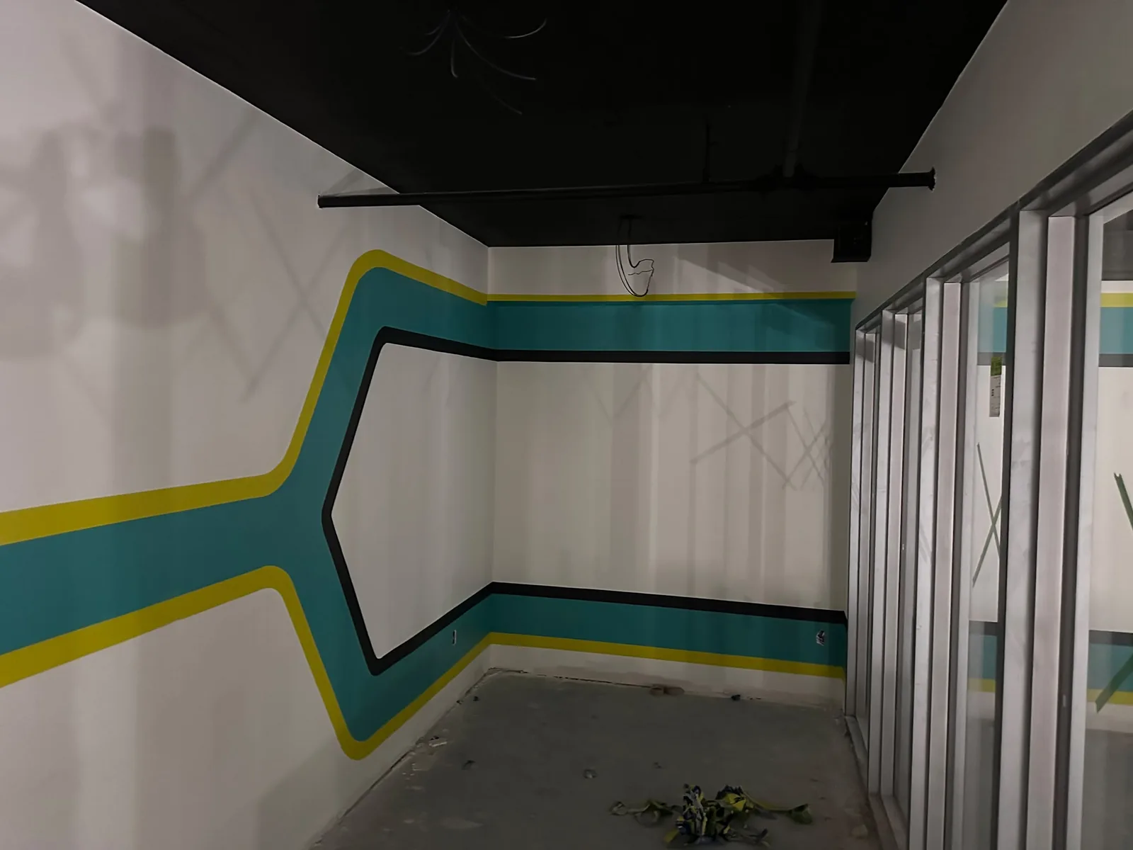 Finished commercial feature wall painting in Guelph with teal, yellow and black lines