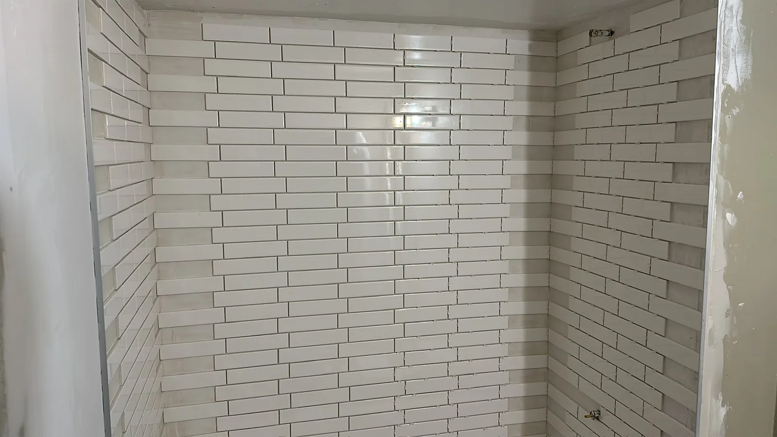 Wide view of white wall tile installation underway in a Kitchener bathroom