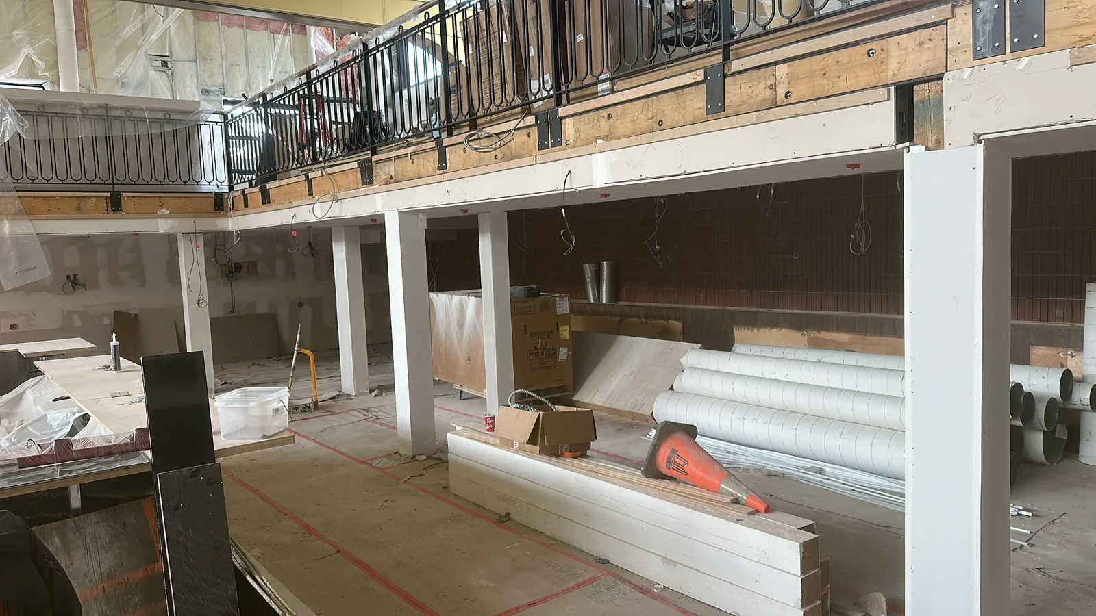Large commercial interior renovation in progress with finished columns and construction materials
